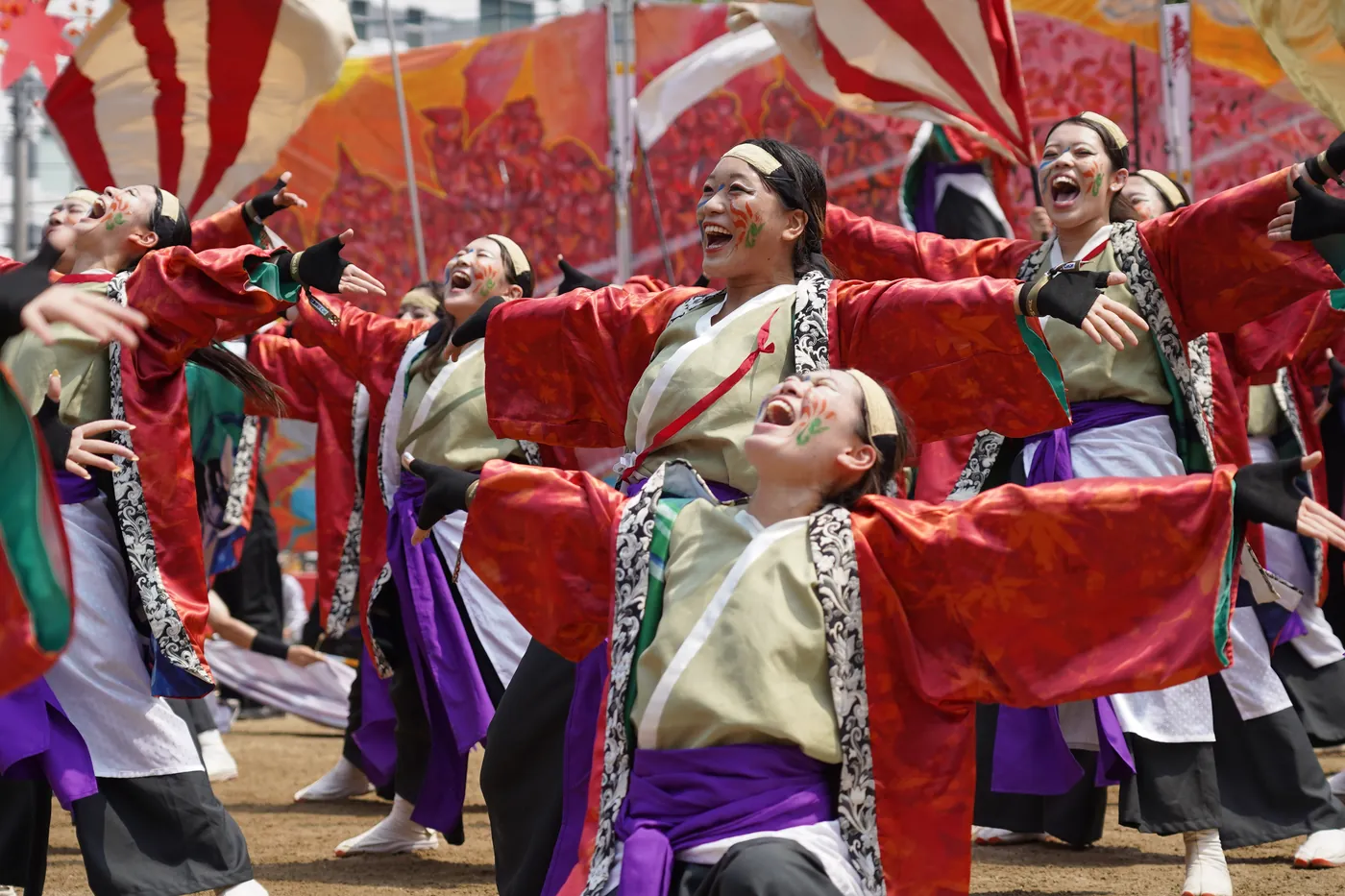 赤い衣装で笑顔を見せる踊り子たち